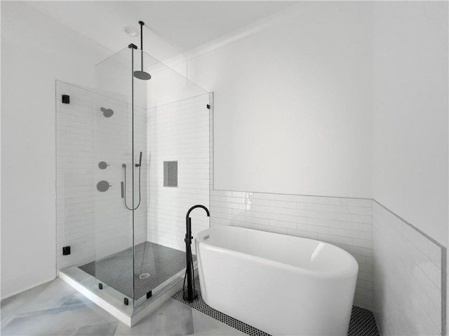 full bathroom with a freestanding tub and a shower stall