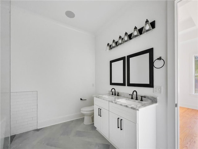 bathroom with double vanity, a sink, crown molding, and toilet
