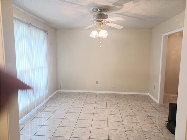 empty room featuring a textured ceiling, ceiling fan, and light tile patterned flooring