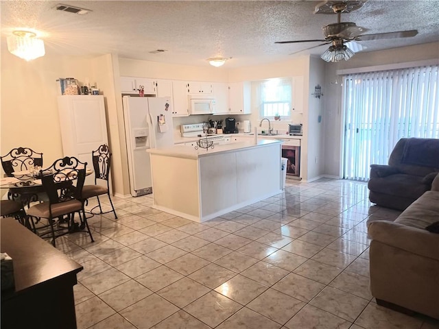 kitchen with sink, white cabinetry, a textured ceiling, a kitchen island, and white appliances