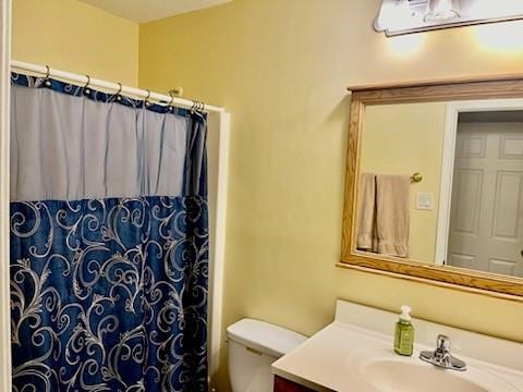 bathroom with vanity, toilet, and walk in shower