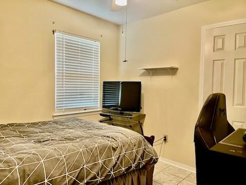 tiled bedroom featuring ceiling fan