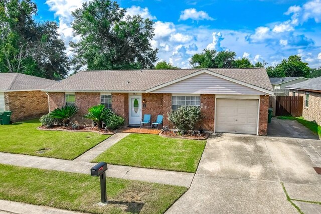 single story home with a garage and a front lawn