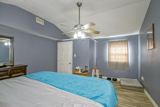 bedroom with lofted ceiling, light hardwood / wood-style flooring, and ceiling fan