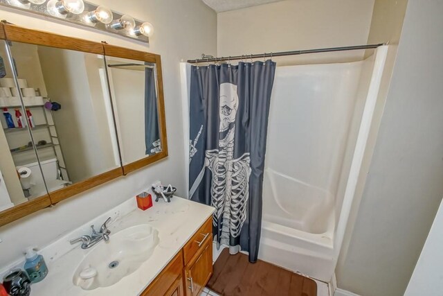 bathroom with vanity, wood-type flooring, and shower / bath combo