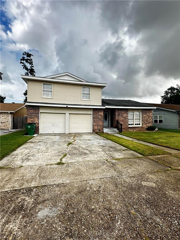 view of property with a garage and a front lawn