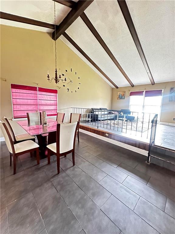 dining area with a textured ceiling, an inviting chandelier, tile patterned floors, and lofted ceiling with beams