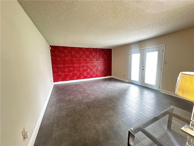 unfurnished room with a textured ceiling and french doors