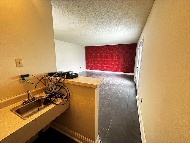 bathroom with tile patterned flooring, sink, and a textured ceiling