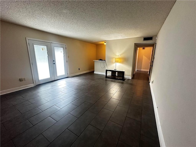 unfurnished living room featuring a textured ceiling and french doors