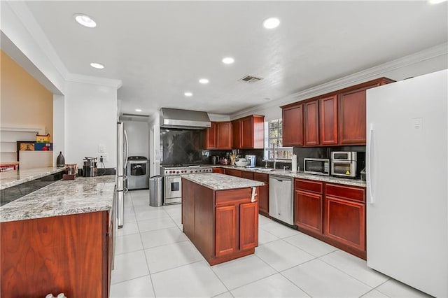 kitchen with light tile patterned floors, stainless steel appliances, light stone counters, decorative backsplash, and wall chimney exhaust hood