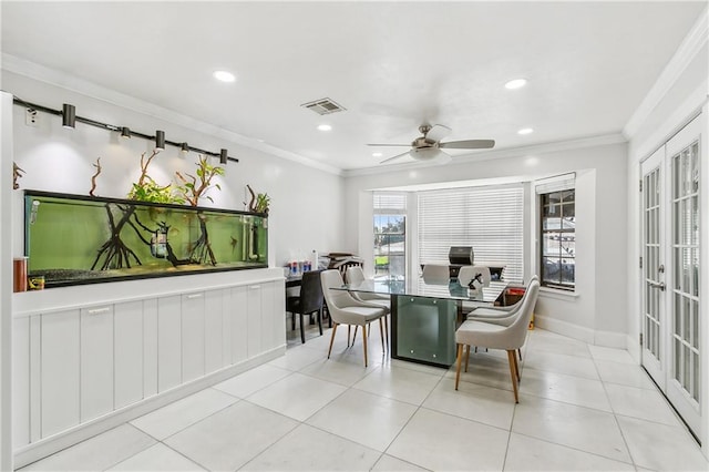 tiled dining room with ceiling fan and ornamental molding