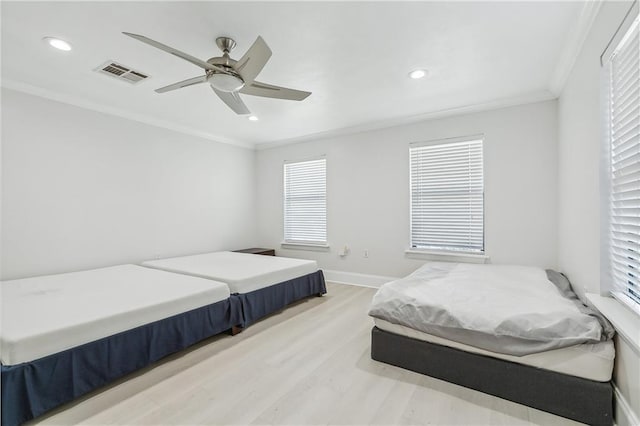 bedroom featuring ceiling fan, ornamental molding, and light hardwood / wood-style flooring