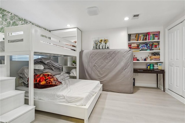 bedroom with light wood-type flooring and a closet