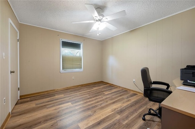 unfurnished office featuring a textured ceiling, crown molding, ceiling fan, and wood-type flooring