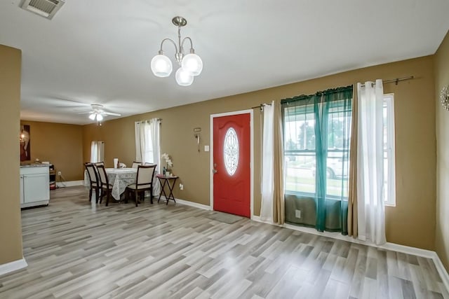 entrance foyer with light wood-type flooring and ceiling fan with notable chandelier