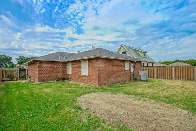 back of property with a lawn and central AC unit