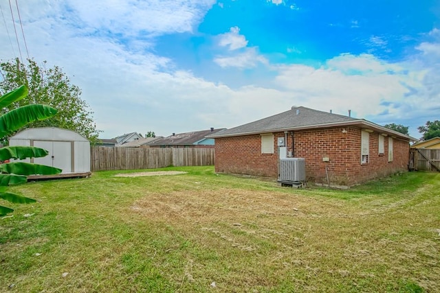 view of yard featuring central air condition unit and a storage unit