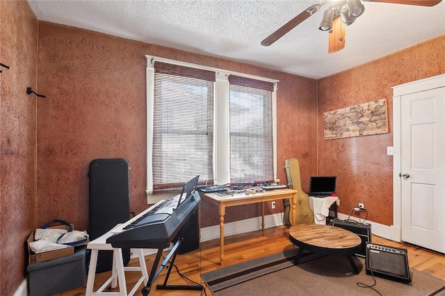 home office featuring a textured ceiling, ceiling fan, and wood-type flooring