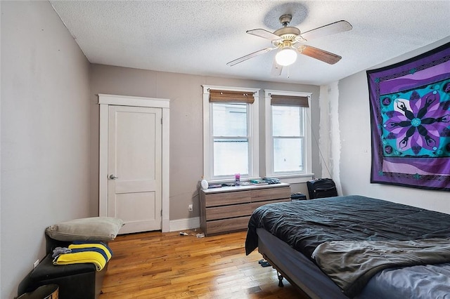 bedroom featuring a textured ceiling, light hardwood / wood-style flooring, and ceiling fan