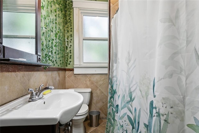 bathroom featuring vanity, backsplash, tile walls, toilet, and tile patterned floors