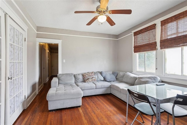 living room featuring ceiling fan and dark hardwood / wood-style flooring