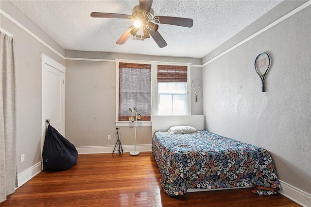 bedroom featuring wood-type flooring, a textured ceiling, and ceiling fan