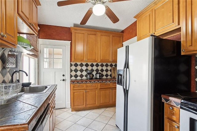 kitchen with stainless steel fridge with ice dispenser, sink, decorative backsplash, ceiling fan, and light tile patterned flooring