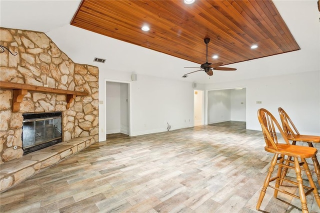 unfurnished living room with wood ceiling, ceiling fan, light wood-type flooring, and a fireplace