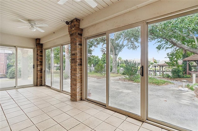 unfurnished sunroom with a healthy amount of sunlight and ceiling fan