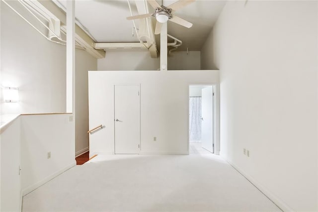 interior space with ceiling fan and a towering ceiling