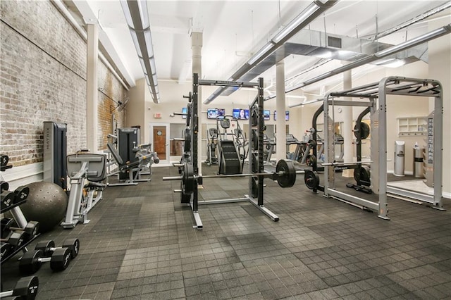 exercise room featuring brick wall