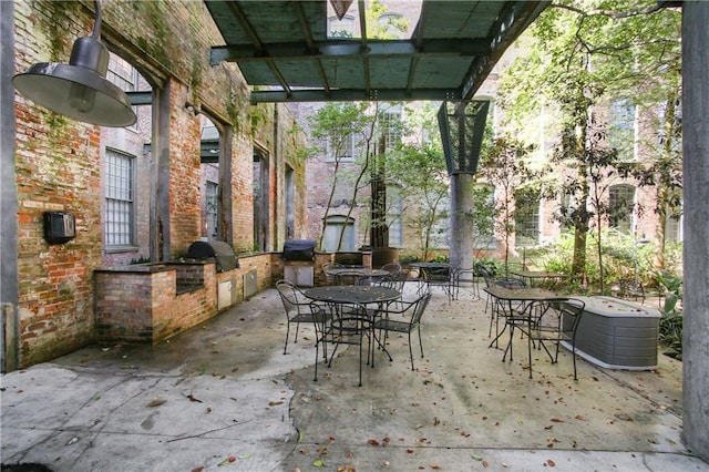 view of patio with exterior kitchen, a pergola, and area for grilling