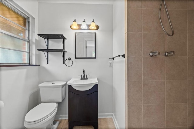 bathroom featuring tiled shower, vanity, and toilet