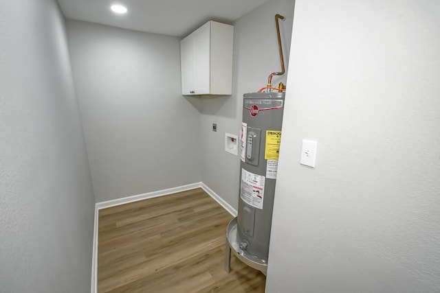 washroom featuring water heater, cabinets, washer hookup, wood-type flooring, and hookup for an electric dryer