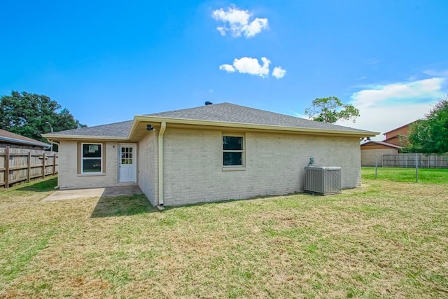 back of house featuring a yard and central AC