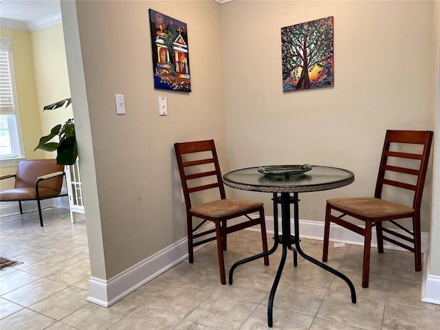 dining area featuring light tile patterned floors and ornamental molding