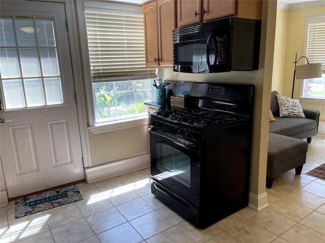 kitchen with black appliances, light tile patterned floors, and ornamental molding