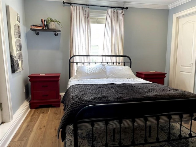 bedroom featuring ornamental molding and light wood-type flooring