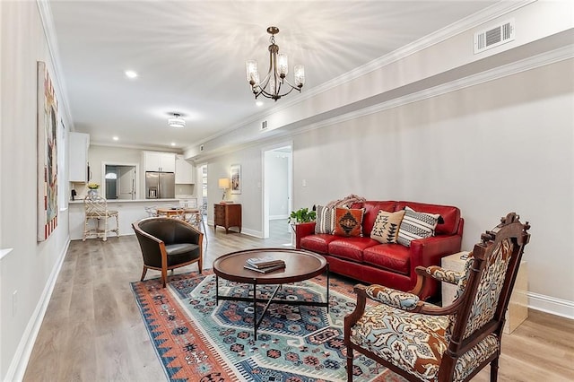 living room featuring light wood-type flooring, ornamental molding, and a chandelier