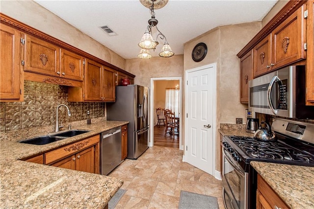 kitchen with sink, hanging light fixtures, backsplash, a chandelier, and appliances with stainless steel finishes