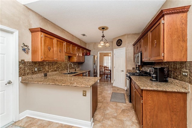 kitchen with pendant lighting, appliances with stainless steel finishes, tasteful backsplash, a notable chandelier, and kitchen peninsula