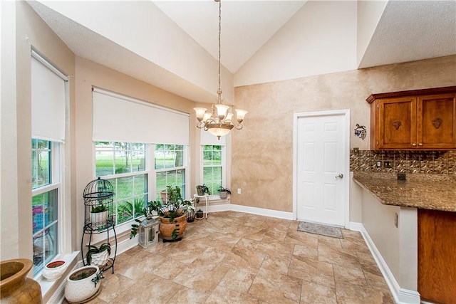 dining area with a notable chandelier, high vaulted ceiling, and a wealth of natural light