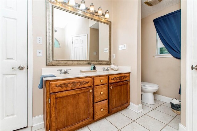 bathroom with tile patterned flooring, vanity, toilet, and a textured ceiling