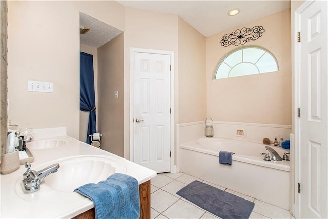 bathroom featuring tile patterned floors, vanity, and a bath