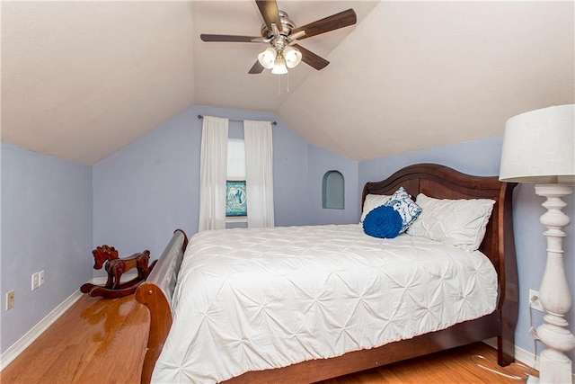 bedroom featuring ceiling fan, wood-type flooring, and vaulted ceiling