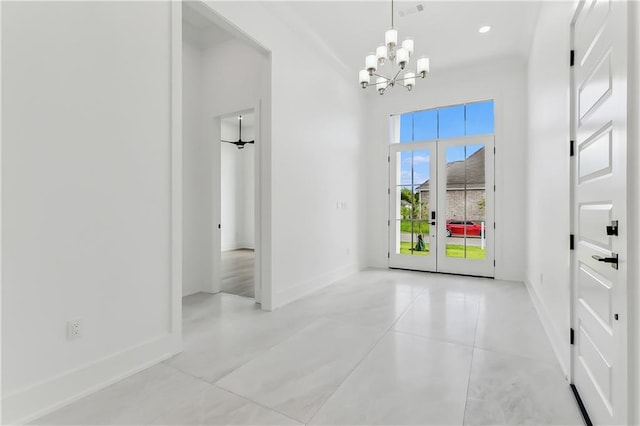 tiled empty room with a notable chandelier and french doors