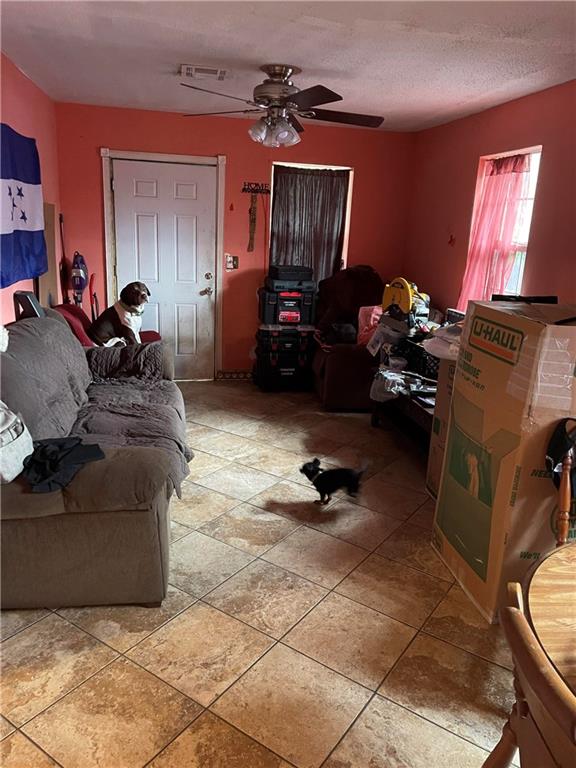 tiled living room featuring ceiling fan