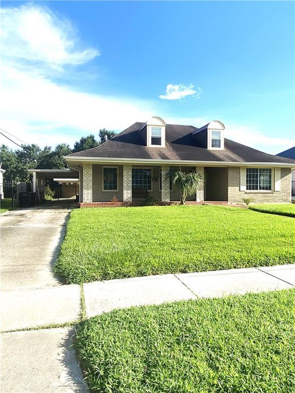 view of front facade featuring a carport, concrete driveway, and a front yard