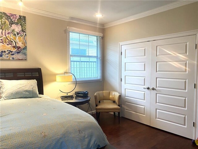 bedroom featuring ornamental molding, dark hardwood / wood-style flooring, and a closet